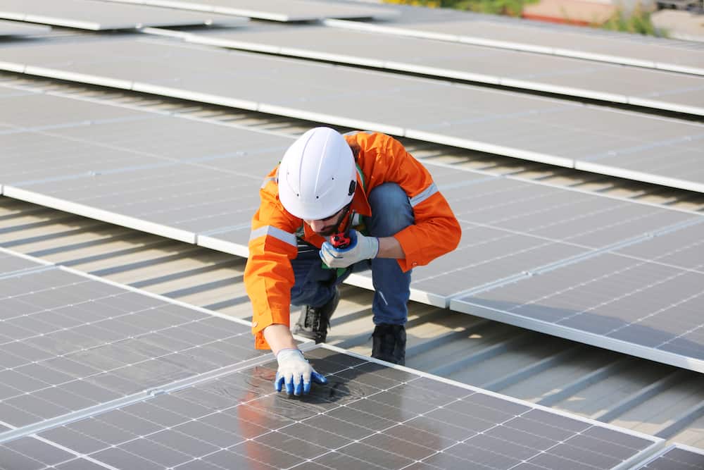 professional-worker-inspecting-solar-panels - Solar Panels for Commercial Buildings