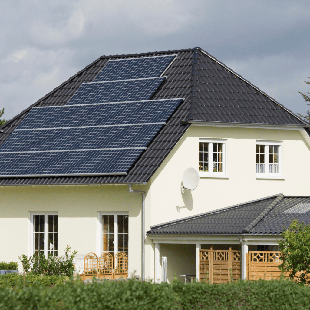 white house with solar panels on the roof - solar energy benefits